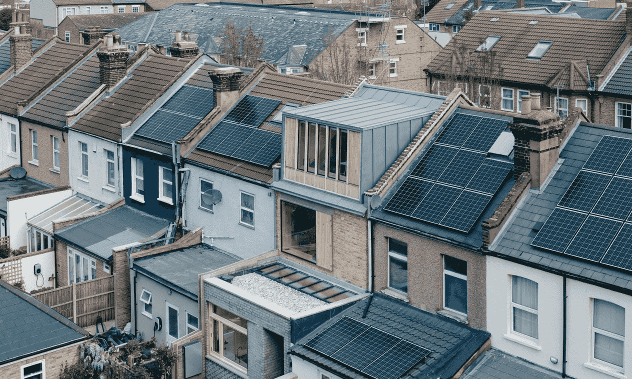 UK terraced rooftops with solar panel arrays at varied pitches and orientations